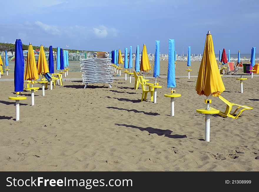 Sun chairs and umbrellas on the sea side in Italy