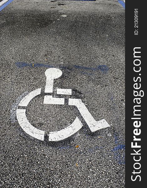 Handicaped parking only space, outside store entrance in a Florida mall, indicated by wheelchair logo painted on the asphalt pavement. Handicaped parking only space, outside store entrance in a Florida mall, indicated by wheelchair logo painted on the asphalt pavement.