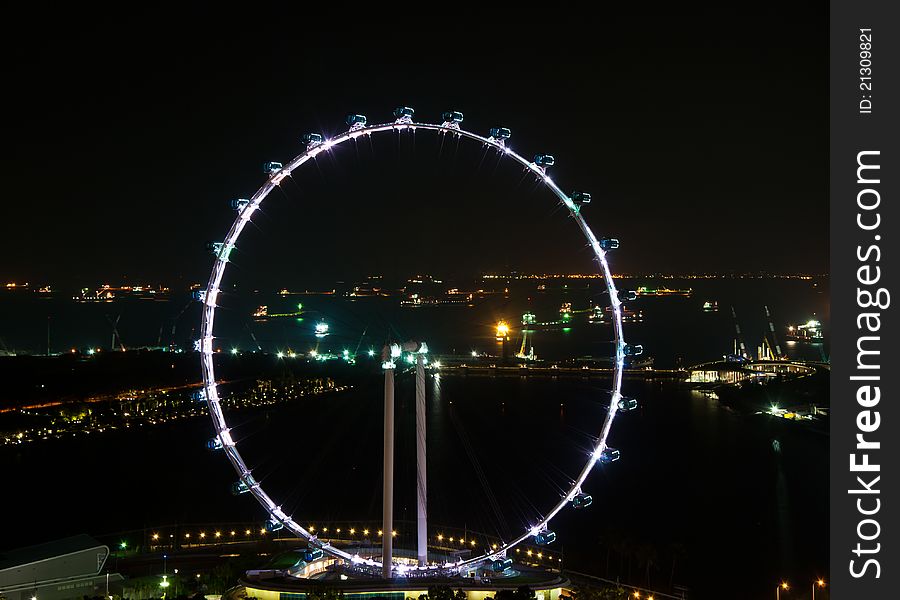 Singapore Flyer â€“ the 165-m high Ferris wheel magnificently lit in the night.