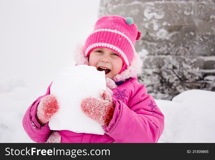 Girl biting piece of snow in winter