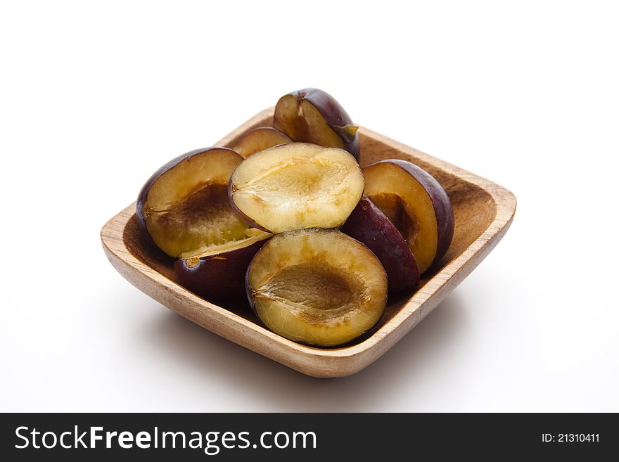 Plums without cores in the wooden bowl