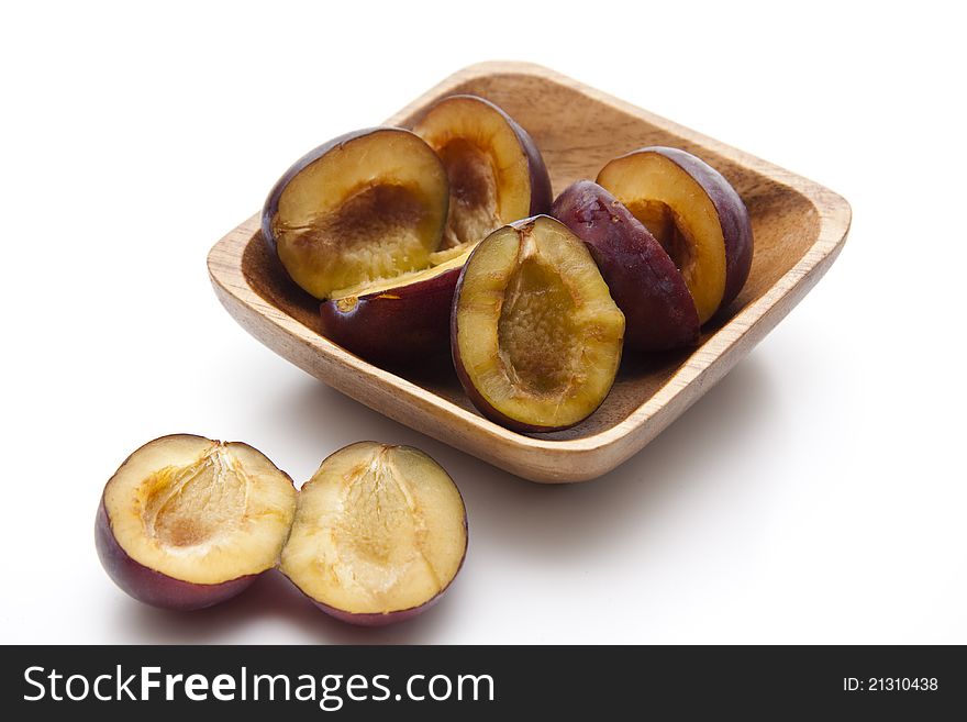 Plums without cores in the wooden bowl