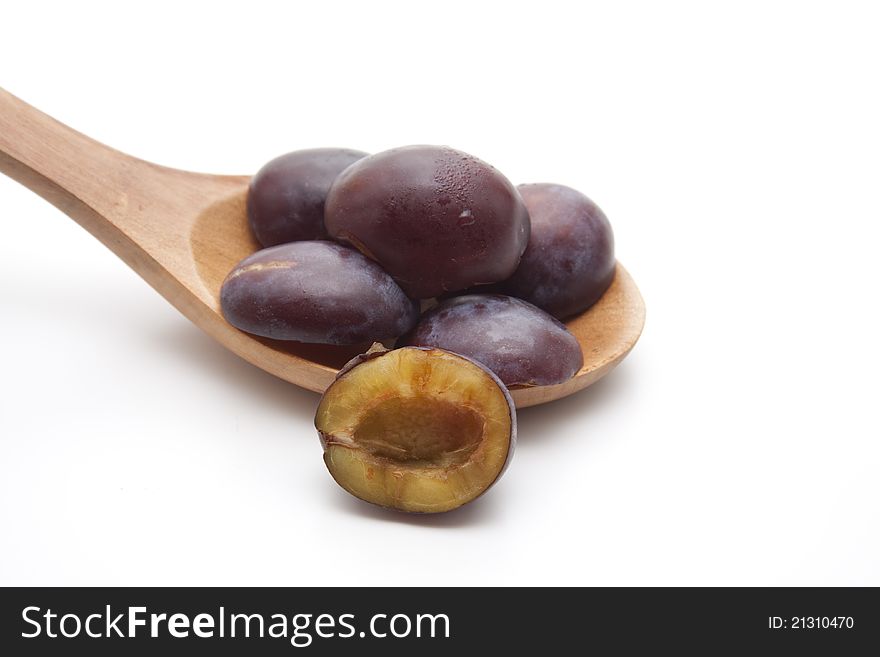 Plums without cores on wooden spoon. Plums without cores on wooden spoon