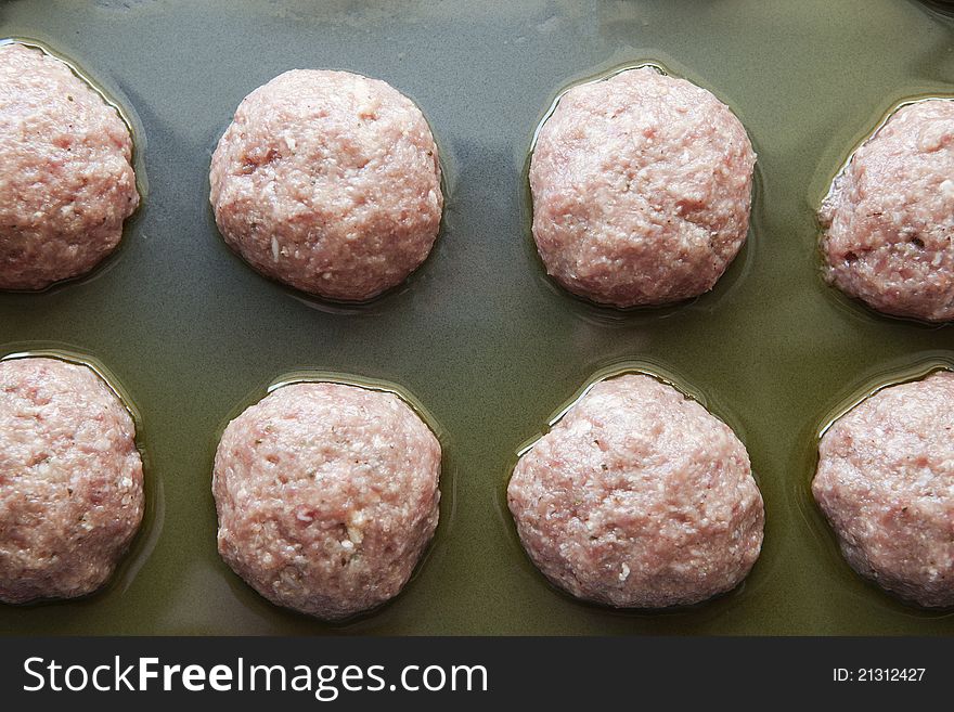 Raw meatballs on a pan, ready for grill