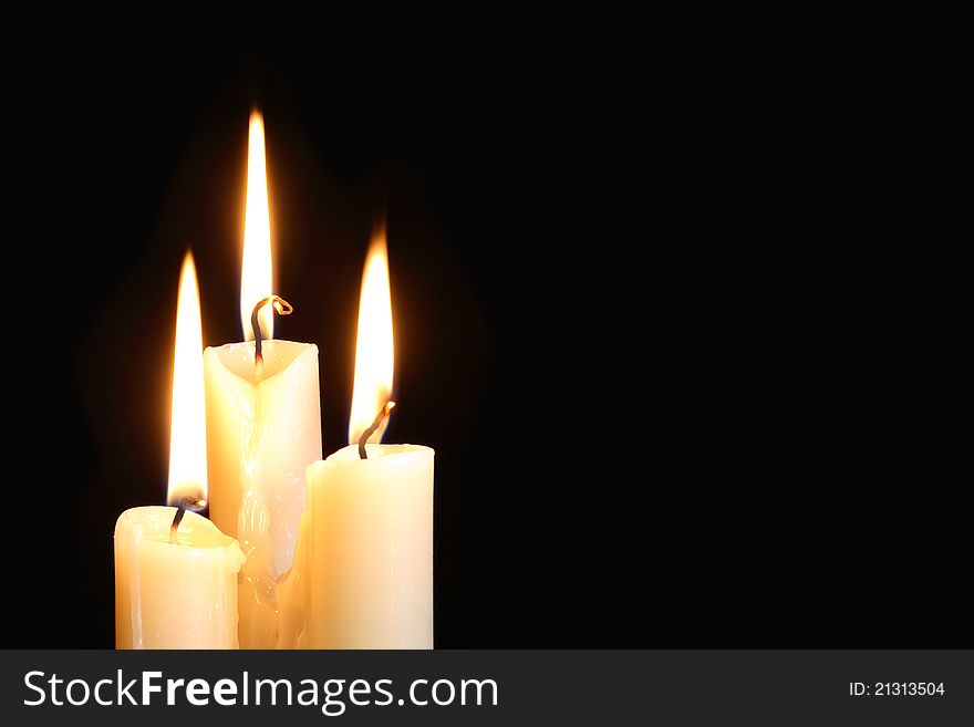 Three ordinary lighting candles on black background with free space for your text