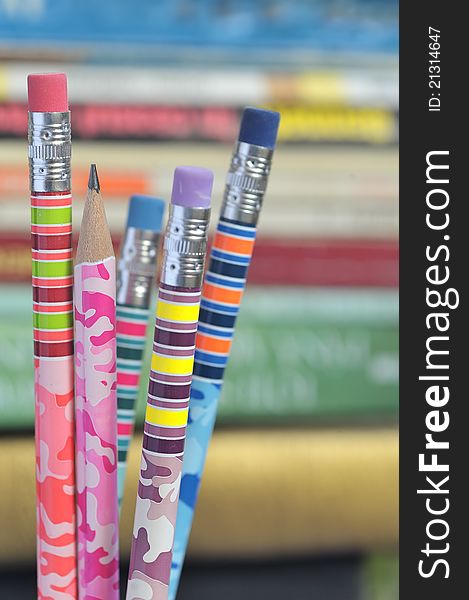 Closeup of colored pencils with books in background