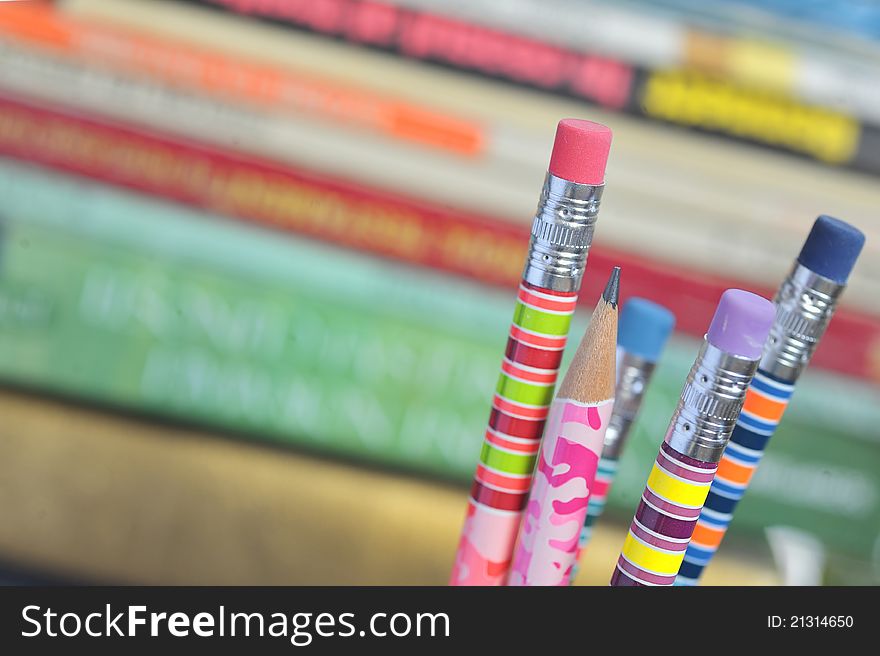 Closeup of colored pencils with books in background