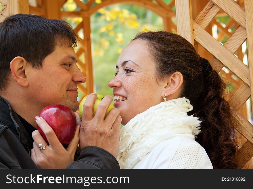 Young happy couple eating apples