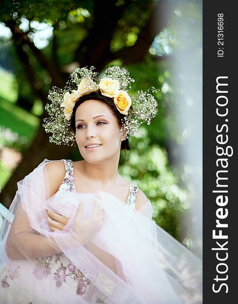 Beautiful woman with a wreath of roses on her head