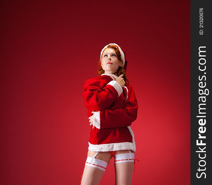 Young sexy woman dressed as Santa looking up. Young sexy woman dressed as Santa looking up