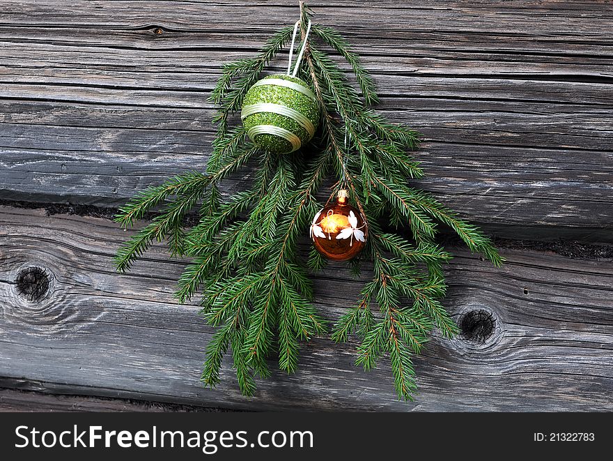 Christmas tree twig and decorations against the background of the shabby wooden wall