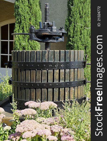 A traditional vertical wine press being on display in a winery.