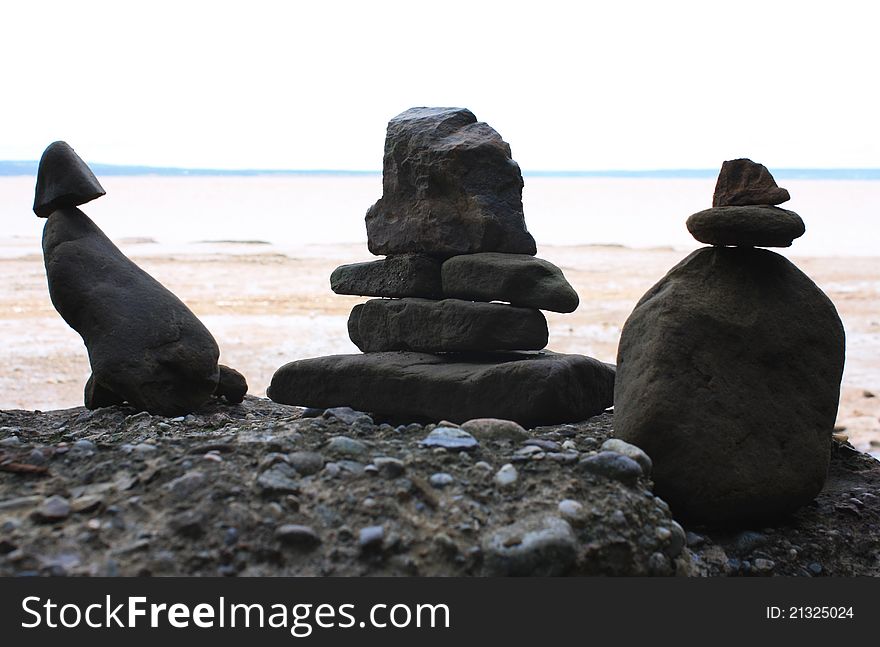 Small inukshuks with ocean in the background