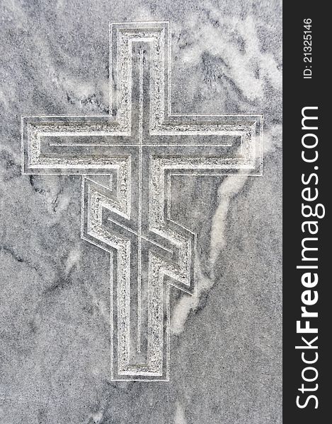 Closeup of orthodox cross carved in gravestone