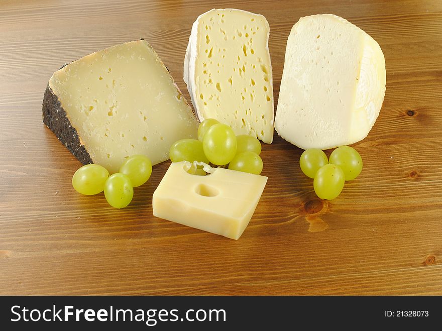 Italian Cheese With Grapes On Wooden Table