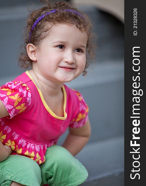 Little girl sitting on the stairs with cute smile. Little girl sitting on the stairs with cute smile.