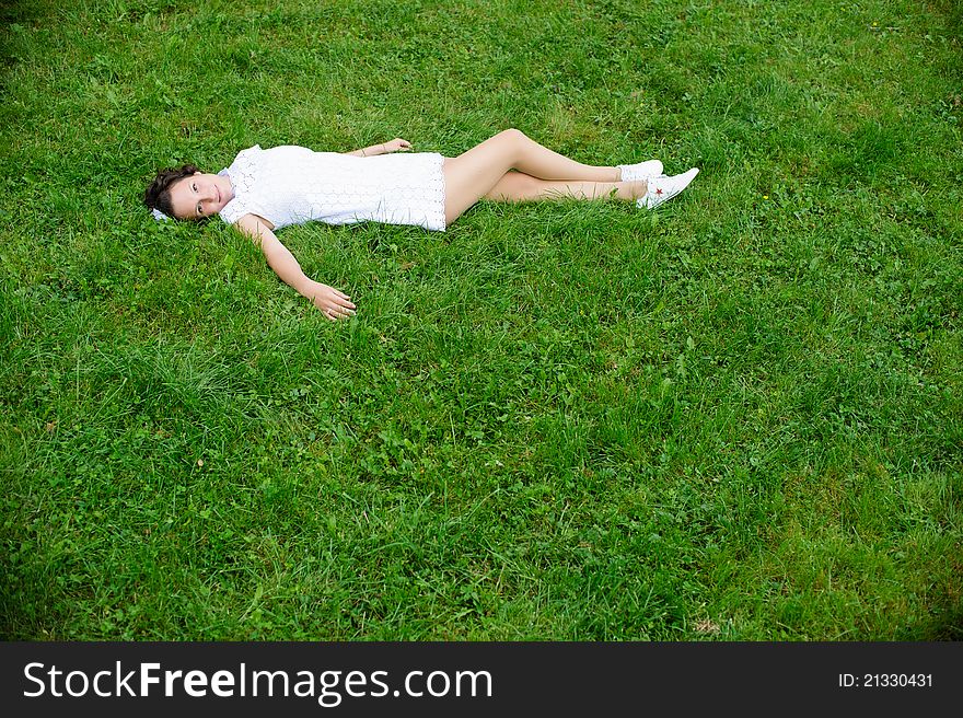 Pretty woman in white laying on the grass