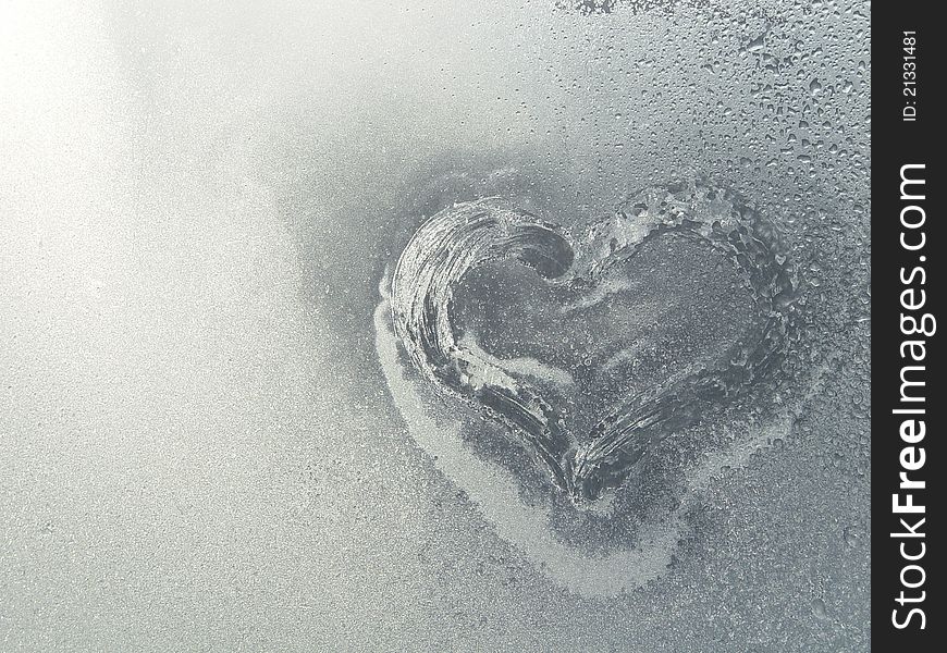 Frozen heart in the frosty window in winter