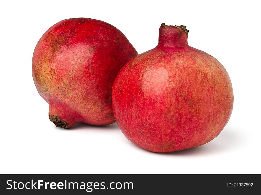 Two pomegranates against white background