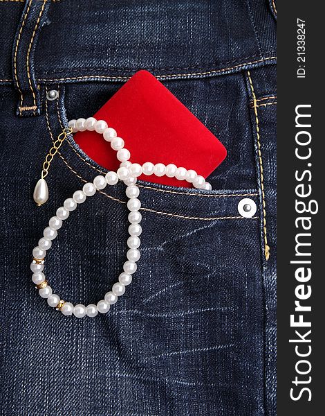 Pearl Necklace and red gift  in jeans pocket. Pearl Necklace and red gift  in jeans pocket