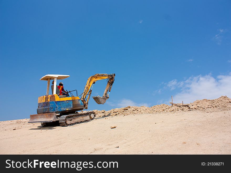 Mini excavator working on earht mountain.