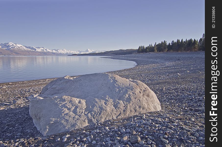Boulder on the shore of Lake Pukaki with Mount Cook in the background. Boulder on the shore of Lake Pukaki with Mount Cook in the background