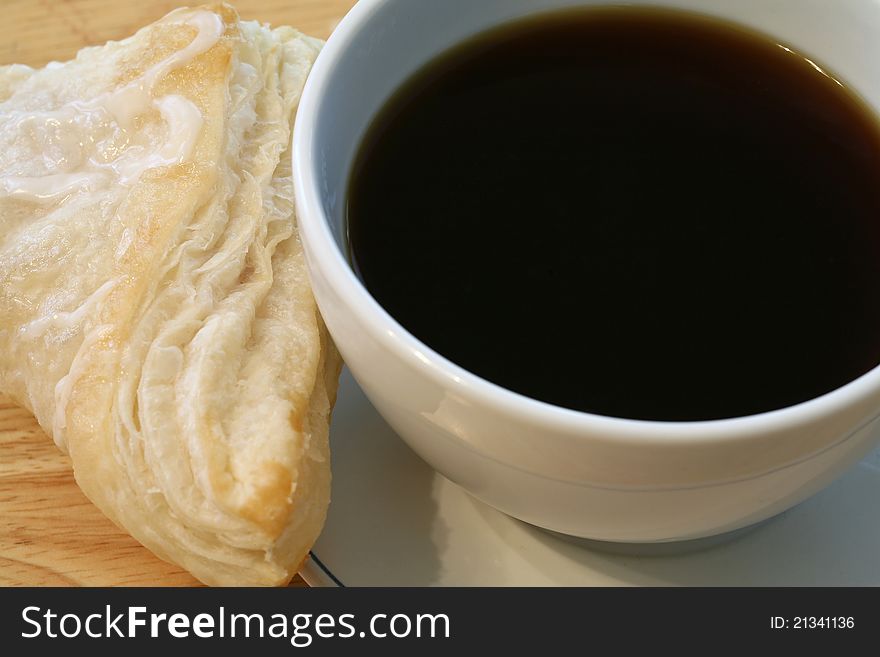 Cup of hot coffee and a fresh backed pastry for breakfast. Cup of hot coffee and a fresh backed pastry for breakfast