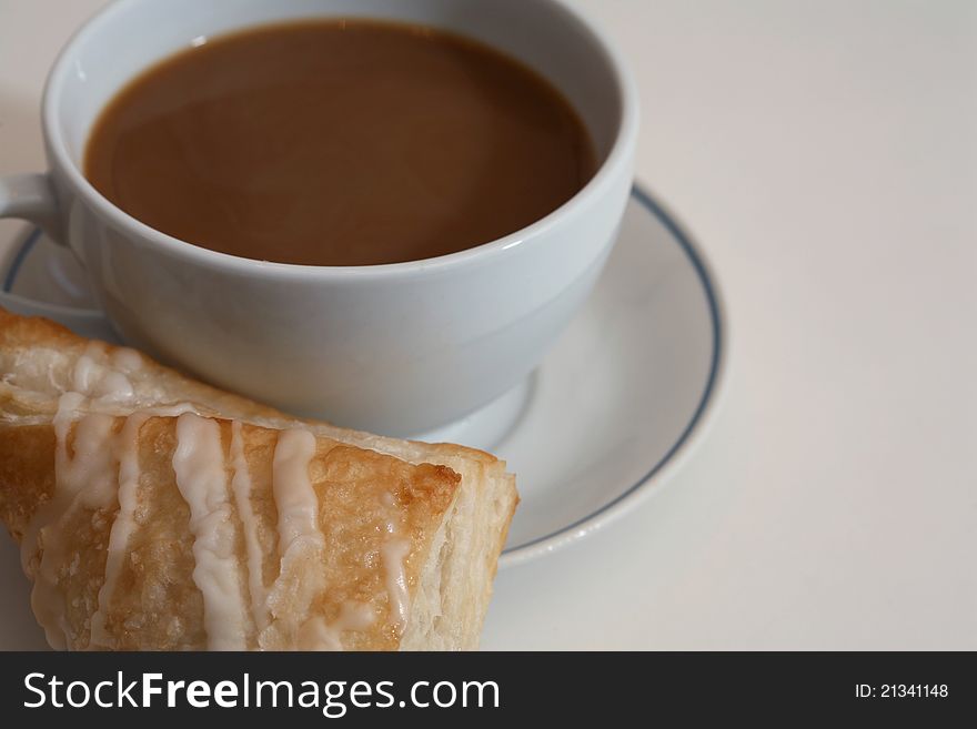 Cup of hot coffee and a fresh backed pastry for breakfast. Cup of hot coffee and a fresh backed pastry for breakfast