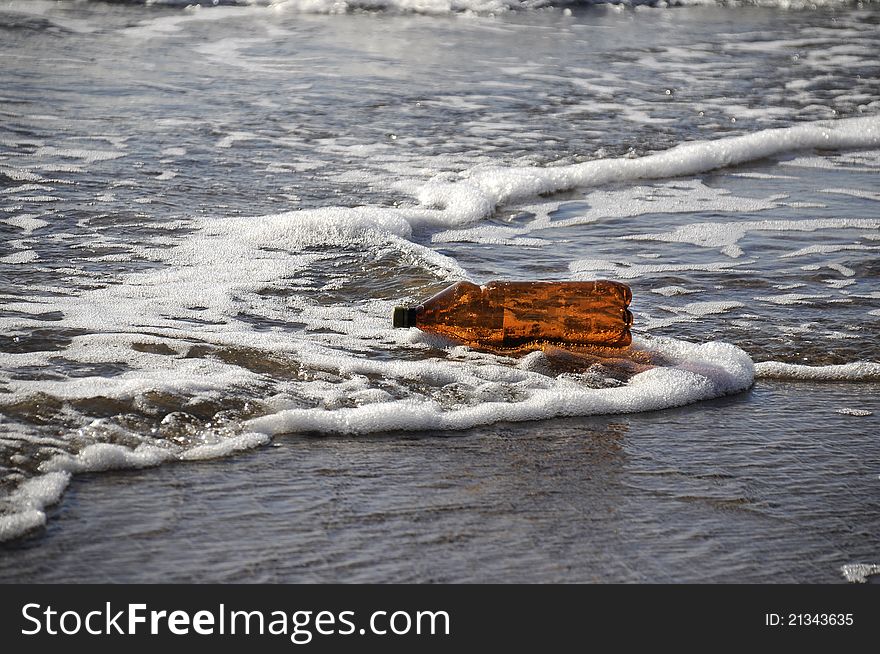 Layjng bottle on seashore in waves. Layjng bottle on seashore in waves