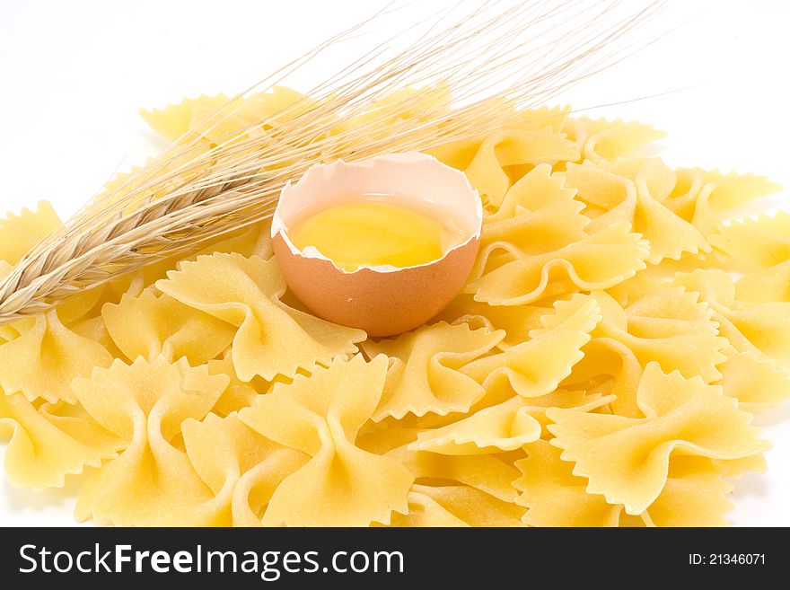 Broken egg, pasta and wheat ears isolated and white background