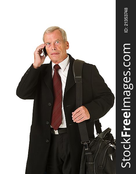 Business man in black suit talking on the phone while on the go. Over a white background. Business man in black suit talking on the phone while on the go. Over a white background