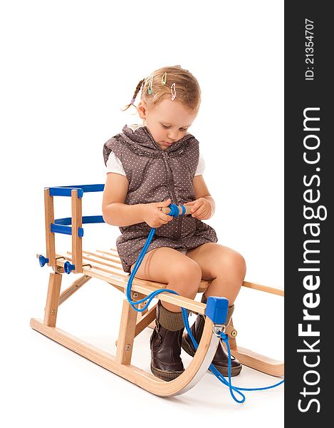 Little girl sitting on sledge in studio on white background. Little girl sitting on sledge in studio on white background