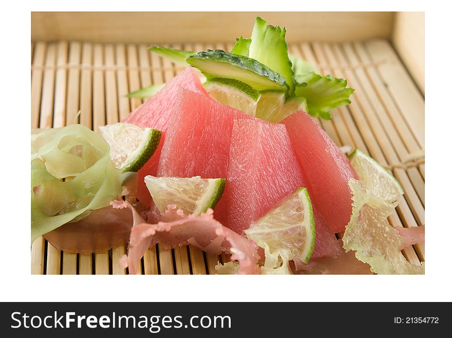 Raw tuna decorated with cucumber and lime