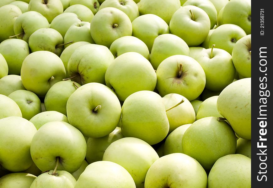 Green apples pile closeup background. Green apples pile closeup background.