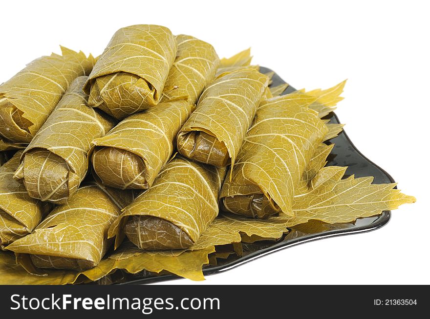 Dolma on a black plate. Isolated on white background. Dolma on a black plate. Isolated on white background.