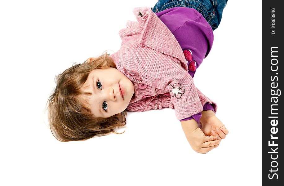 Little girl lying on white floor in the studio