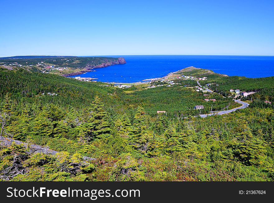 Mountain top view of the coastal town of Flatrock in the province of Newfoundland in Canada. Surrounded by majestic landscape and seascape it is also one of the most visited areas on the East Coast Trail System by tourists. Mountain top view of the coastal town of Flatrock in the province of Newfoundland in Canada. Surrounded by majestic landscape and seascape it is also one of the most visited areas on the East Coast Trail System by tourists.