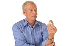 Senior Man With Golden Egg Stock Photos