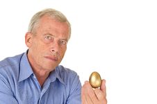 Senior Man With Golden Egg Stock Images