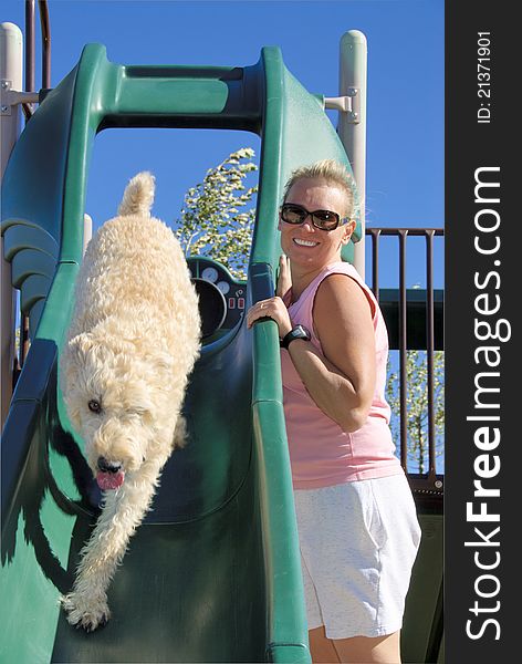 Woman is watching her dog on slide