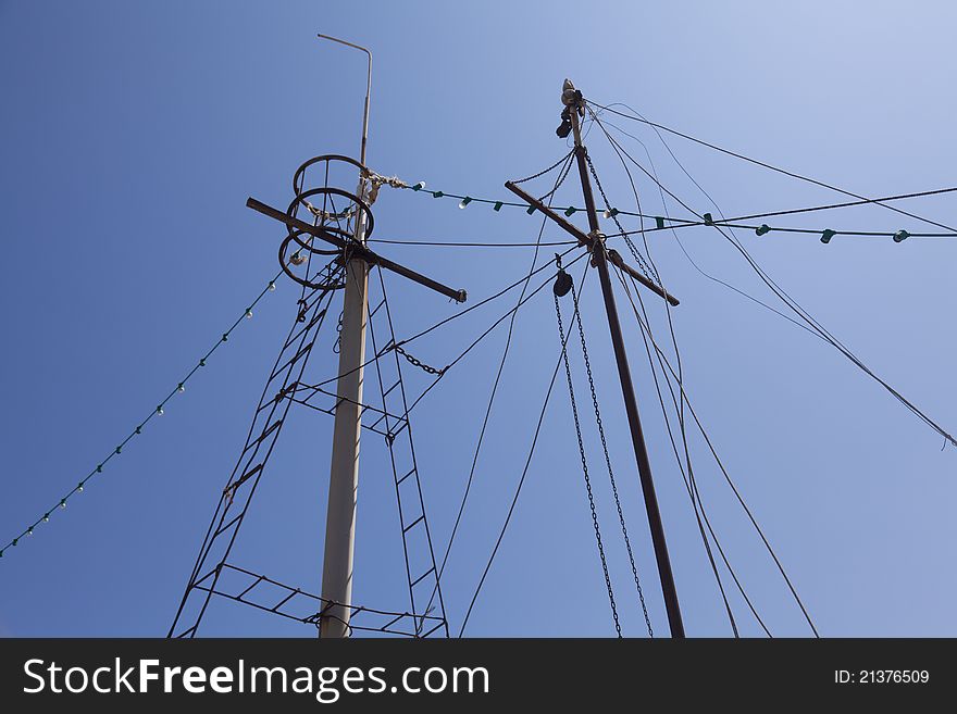 Old boat masts in blue sky