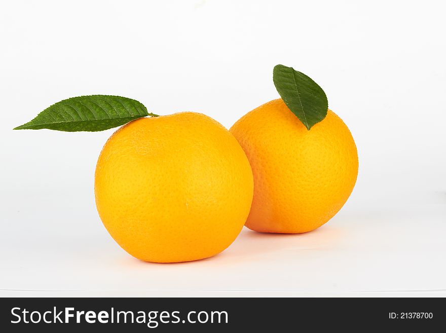 Ripe oranges with leaf on white