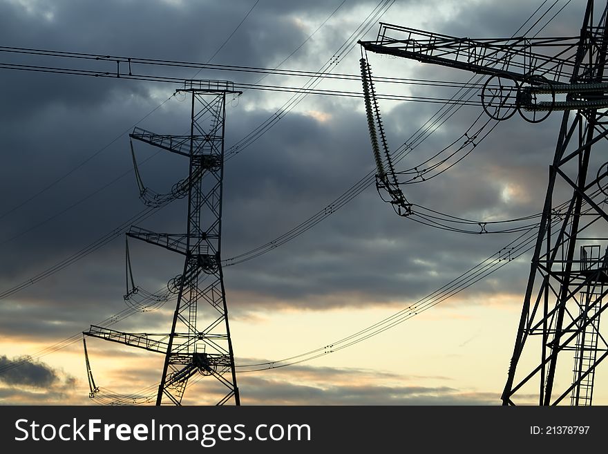 High voltage power pylons on against sunset sky. High voltage power pylons on against sunset sky