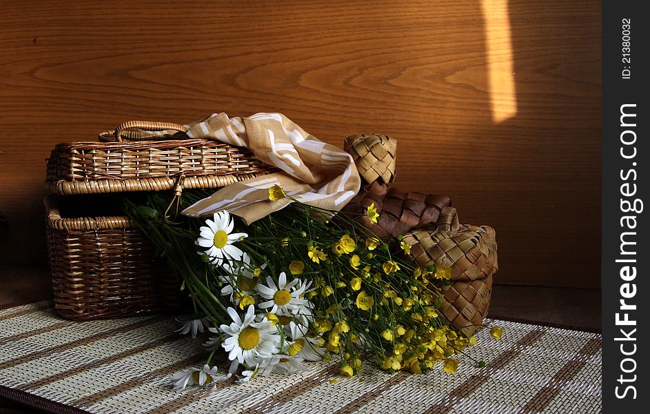 In a basket there are flowers and a female small scarf. In a basket there are flowers and a female small scarf.