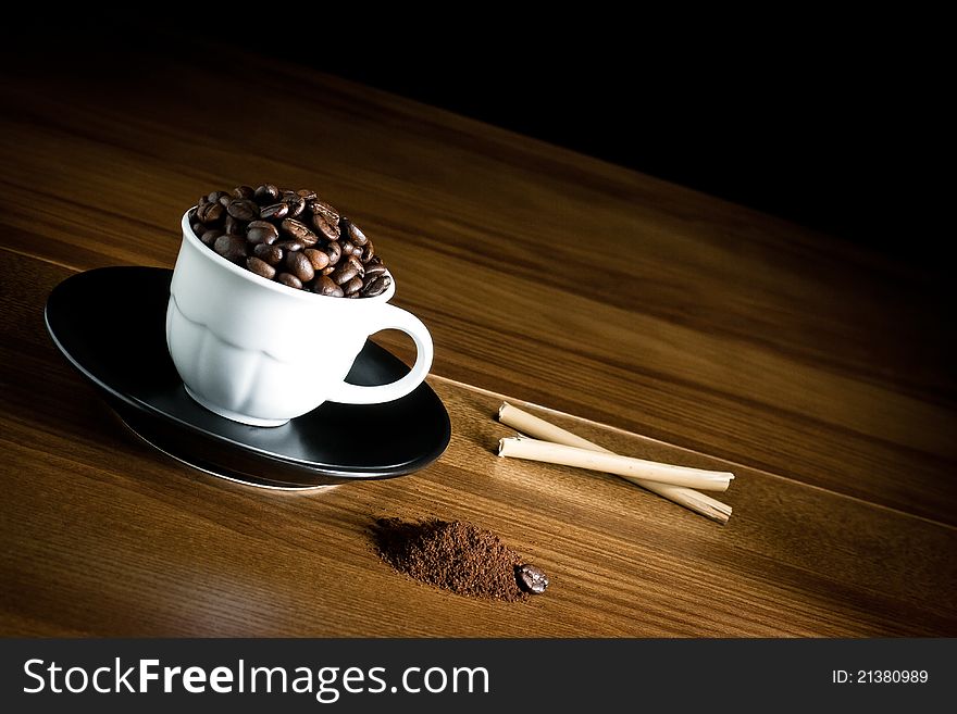 Coffee beans in cup and powdered on wood. Coffee beans in cup and powdered on wood