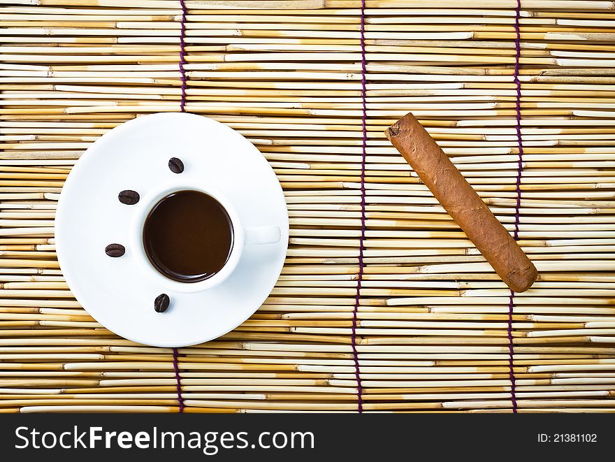 Coffee in cup and cigar on burlap of bamboo