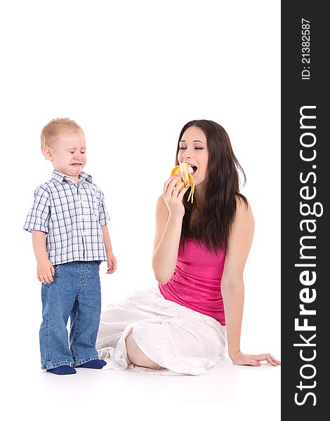 Child crying mother eat banana over white background