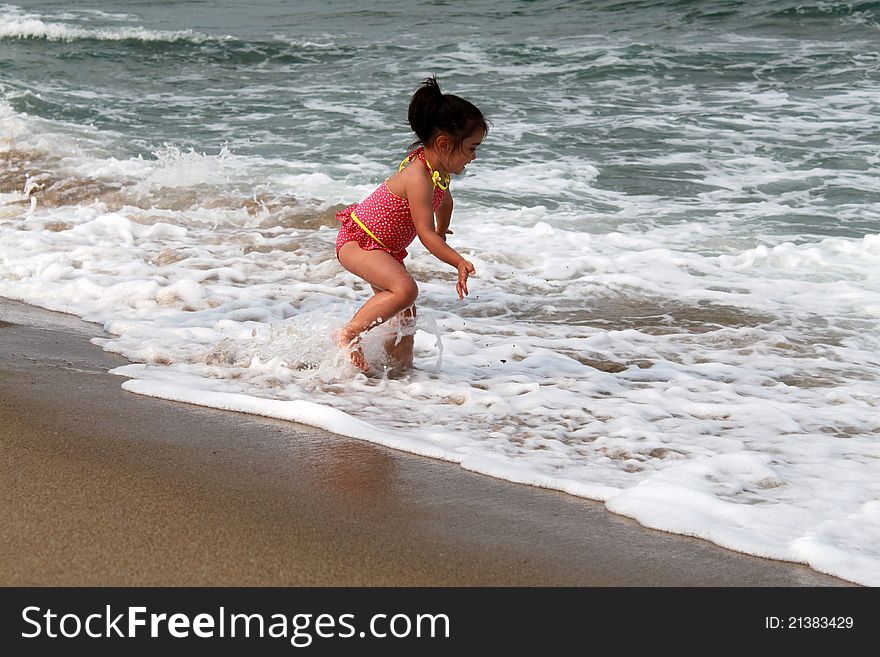 Cute little girl playing on the beach