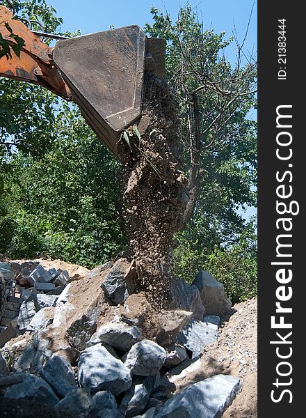 Excavator who pours the granite boulders