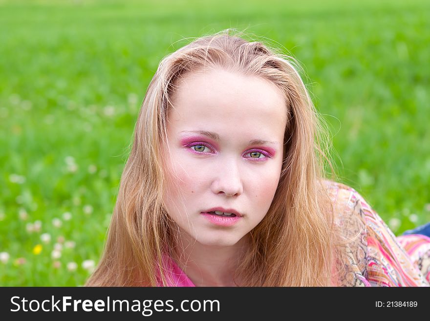 Closeup portrait of a beautiful young girl in a meadow in summer. Closeup portrait of a beautiful young girl in a meadow in summer